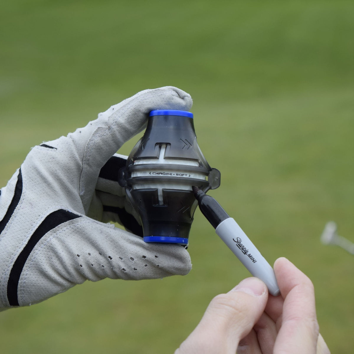 En person med golfhandske håller i produkten Alignment tool och visar hur man skall använda den.