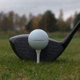 Närbild på Titleist AVX som ligger upp peggad framför en driver.