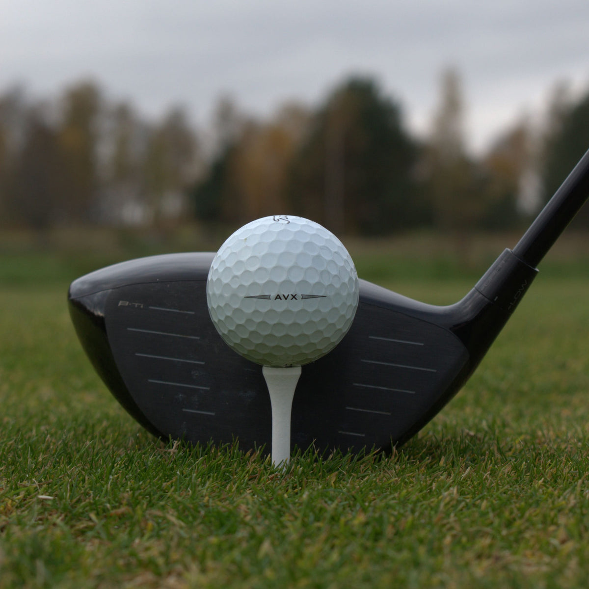 Närbild på Titleist AVX som ligger upp peggad framför en driver.