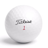 Närbild på Titleist golfboll med logga och röd siffra